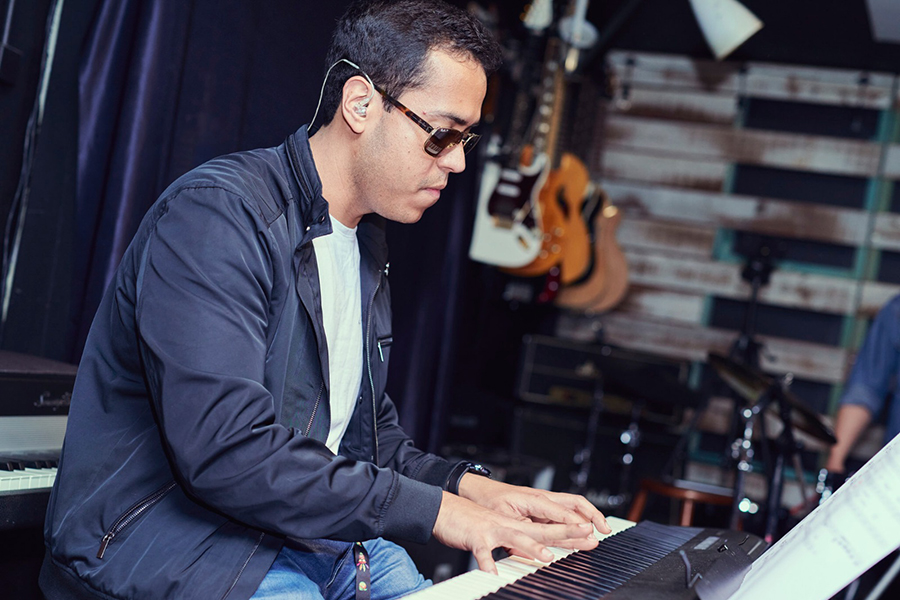 Music teacher performing on a keyboard at a concert in Adelaide, showcasing their talent and inspiring the audience.