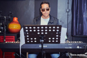 Music teacher at Besharp Music School in Adelaide demonstrating keyboard teaching methods to students, fostering musical skill and passion.