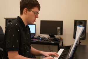 Gallery - Gallery Music School. Image of a teenager playing the piano in a music school, showcasing their talent and passion for music as they skillfully press the piano keys, guided by their music teacher, in pursuit of musical excellence and self-expression. Adelaide piano instruction, piano lessons Adelaide, Adelaide piano classes, Adelaide piano tutoring, Linden Park SA piano instruction.