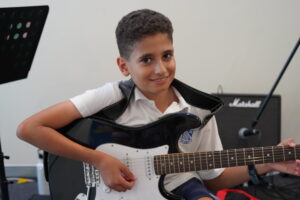 Gallery Music School, Young boy practicing guitar under the guidance of his instructor at Besharp Music School, Adelaide., cello instructor near me, music and movement classes for toddlers, huitar lessons, music high school, art school, mysic school, music shops in adelaide, music lesson adelaide, preschool music class, kids flute lessons, high school music school, flute training near me, school music instruments, saz lessons, toddler music class, music class for children near me, deum lessons, music classes for toddlers near me, music classes kids, music store adelaide, music lessons brighton, keyboard teacher near me, learn banjo, music keyboard lessons, private violin lessons, open music academy adelaide, violin lessons for kids, percussion teacher near me, harmonium lessons near me, music lessons for 4 year olds near me, music lessons and production adelaide australia, music academy, violin lesson, violin teachers near me, musician course, cello lessons for adults near me, ukulele workshop, writing classes for kids, writing classes for kids near me, best violin classes near me, saxophone lessons for adults, 