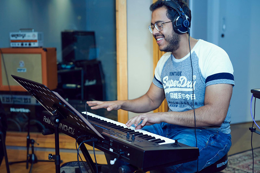 Music teacher expertly playing the keyboard at Besharp Music School, Adelaide, mentoring students in musical development.