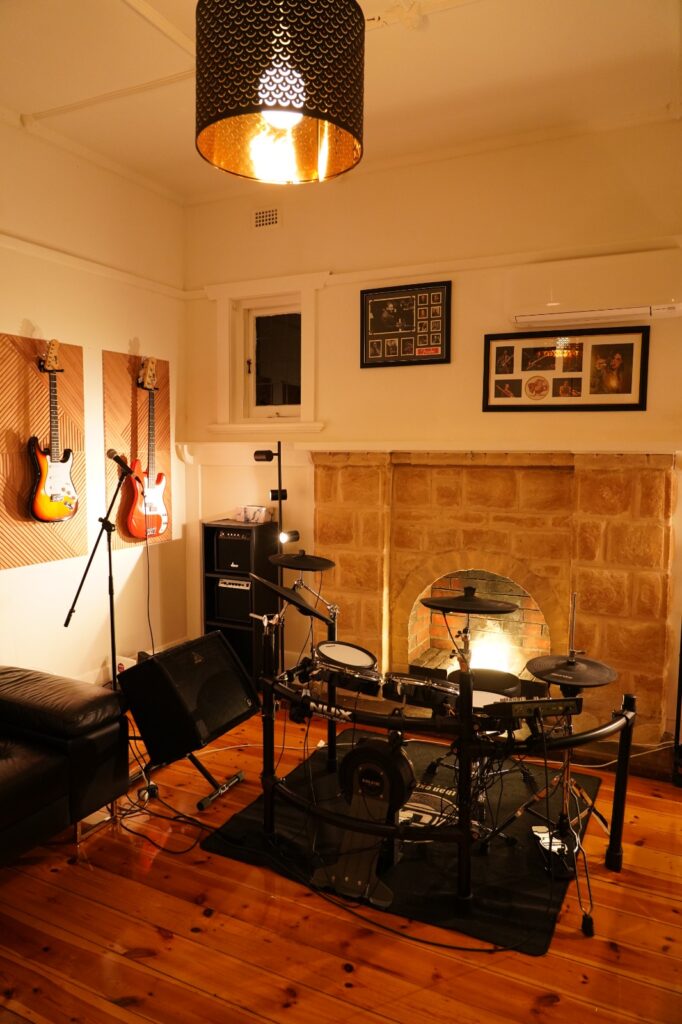 Electronic drum lesson room with guitars and fireplace at BeSharp Music School Adelaide