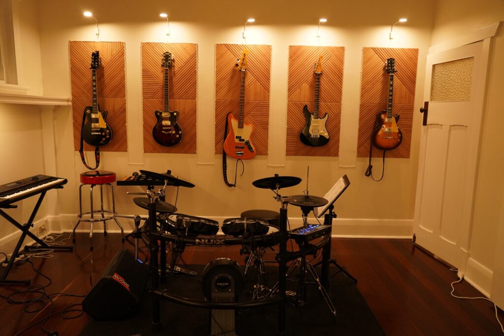 Electronic drum kit in the BeSharp drum lessons studio with guitar wall in Tusmore