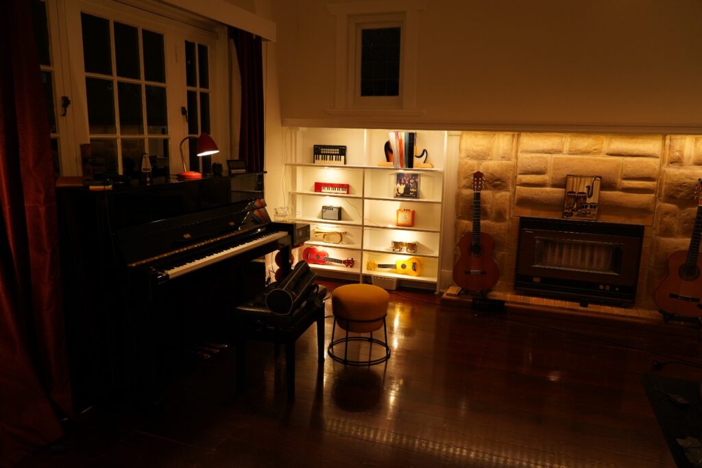 Piano lessons room with upright piano and classical guitars at BeSharp Music School Adelaide